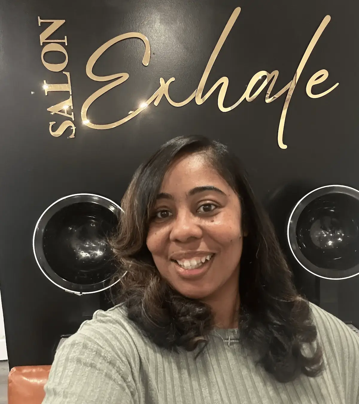 Client with a classic press and curl at Salon Exhale, featuring sleek, straightened hair with a smooth finish