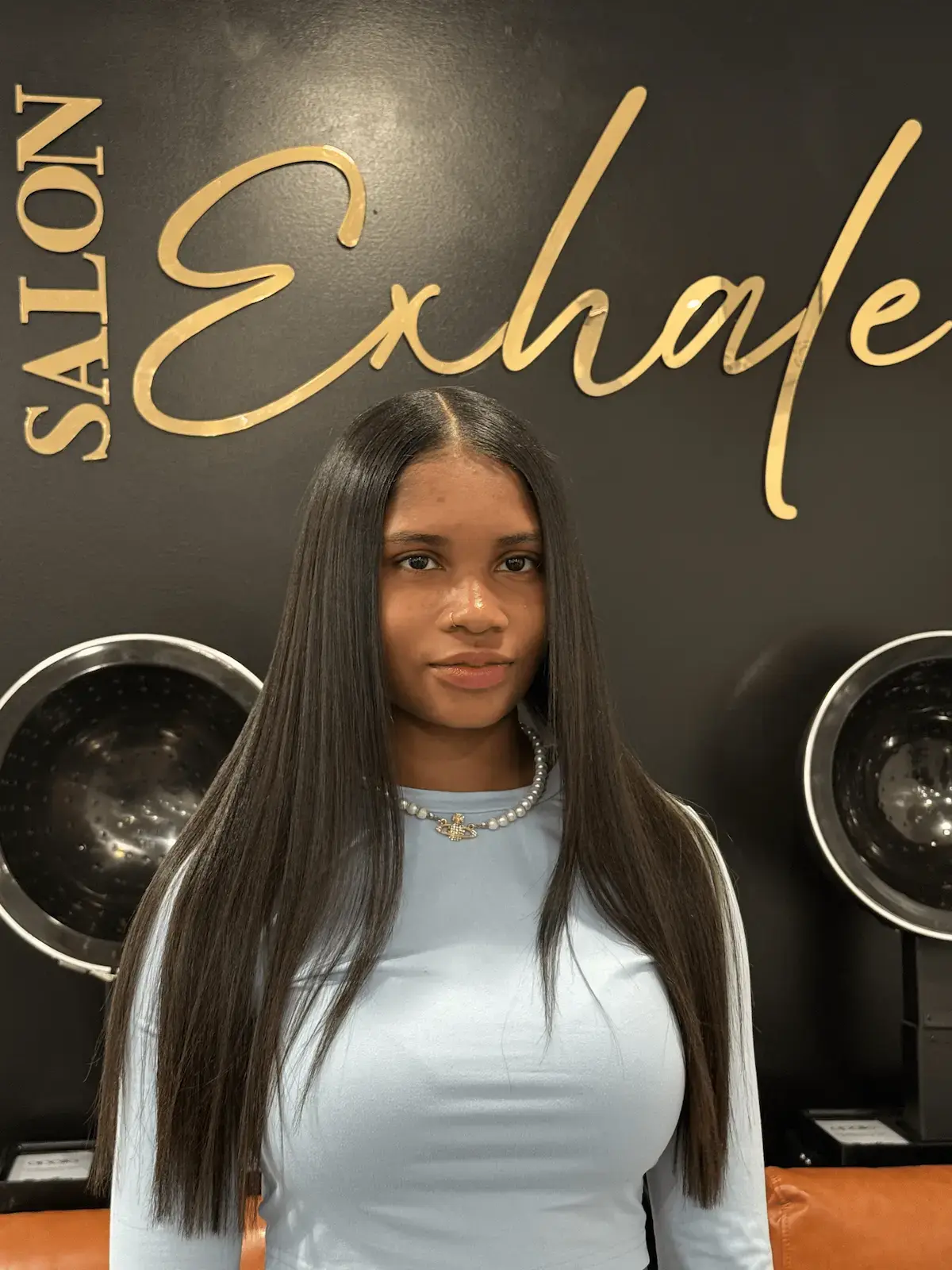 Client with a signature silk press at Salon Exhale, featuring smooth, glossy hair with soft curls